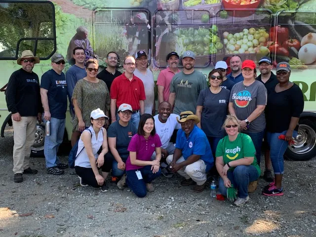 A volunteer group posing in front of the Metro Atlanta Urban Farm produce truck